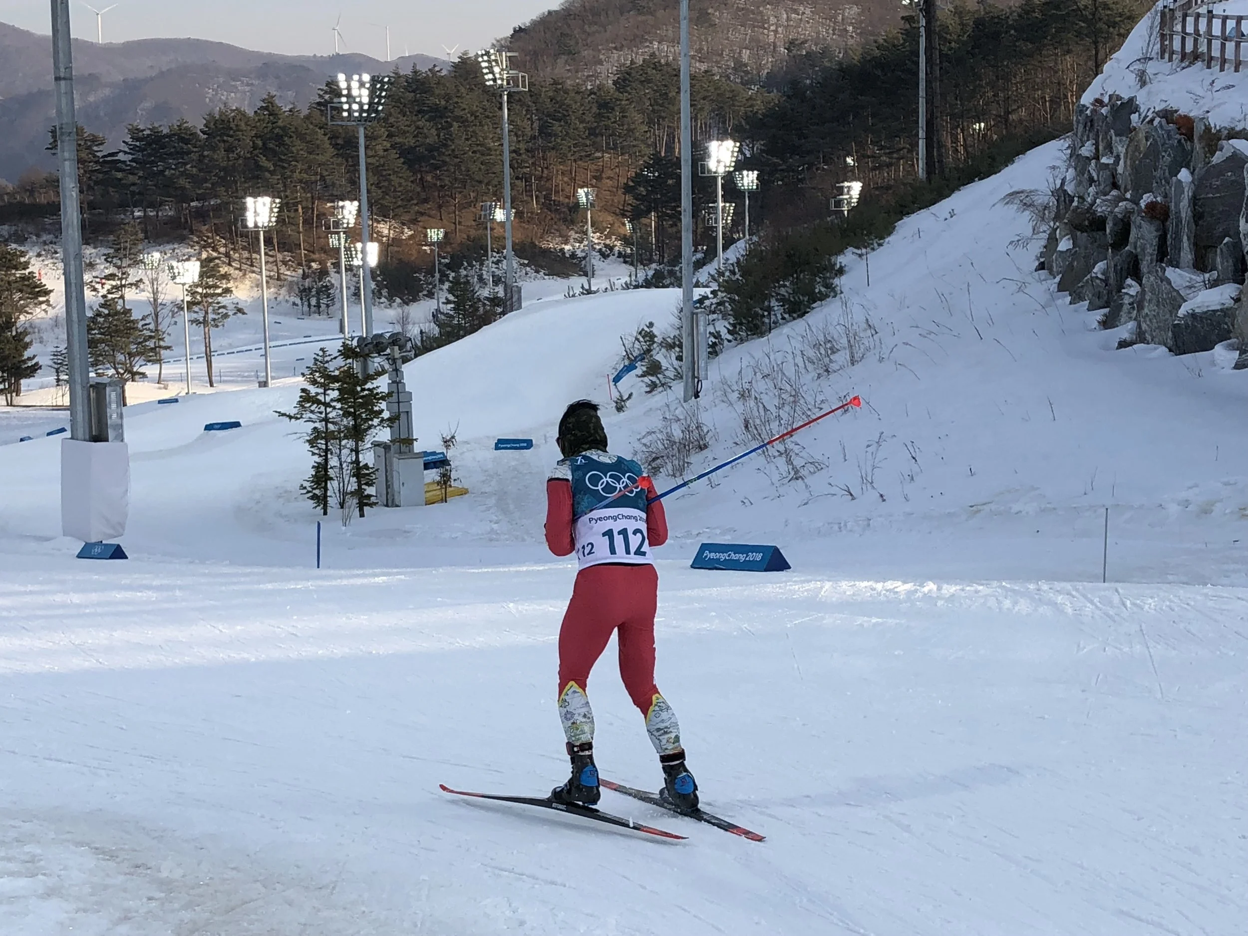 Kequyen Lam racing the 15 km skate race in PyeongChang South Korea. Lights on in the background.