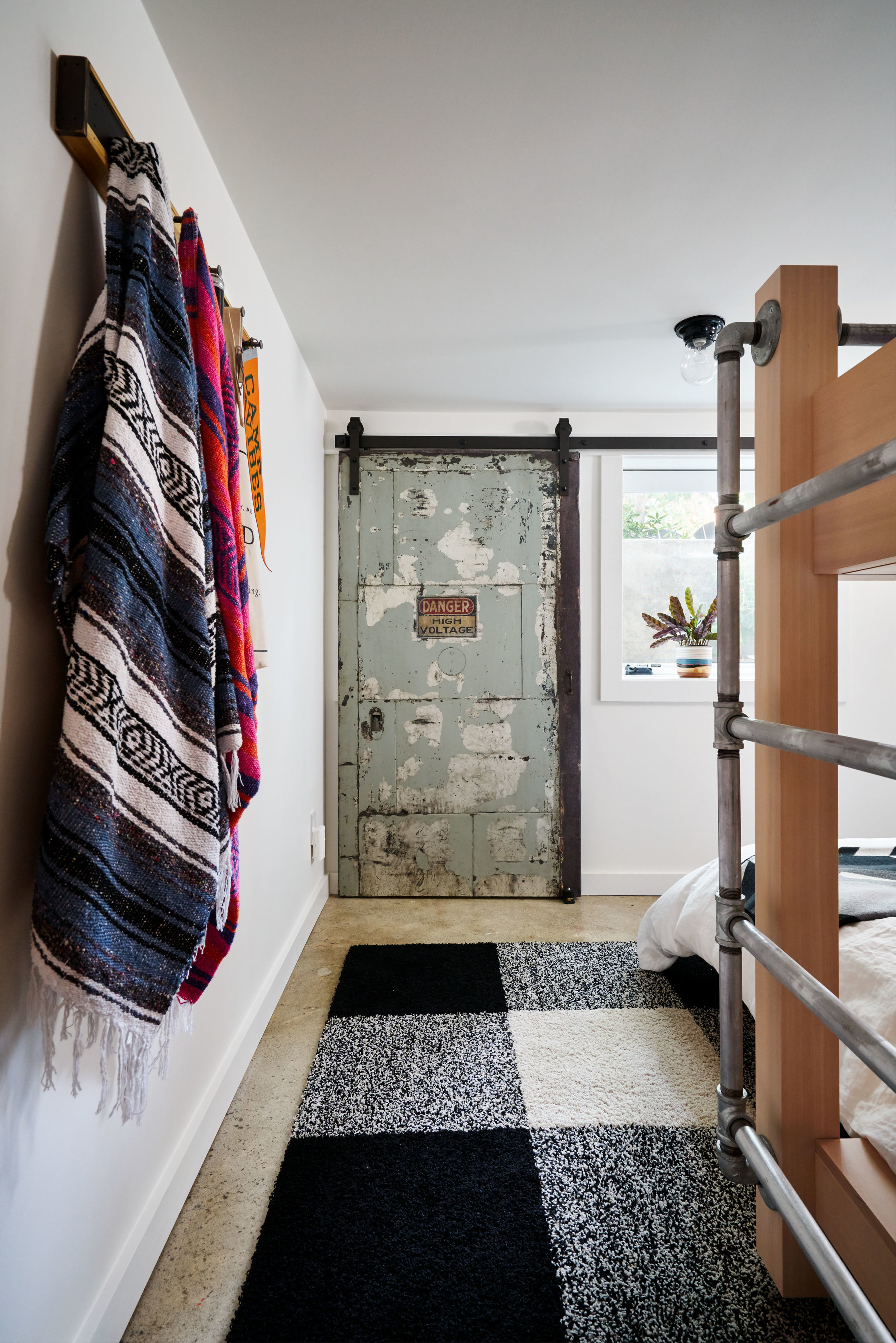 Salvaged metal door hides electrical panel.