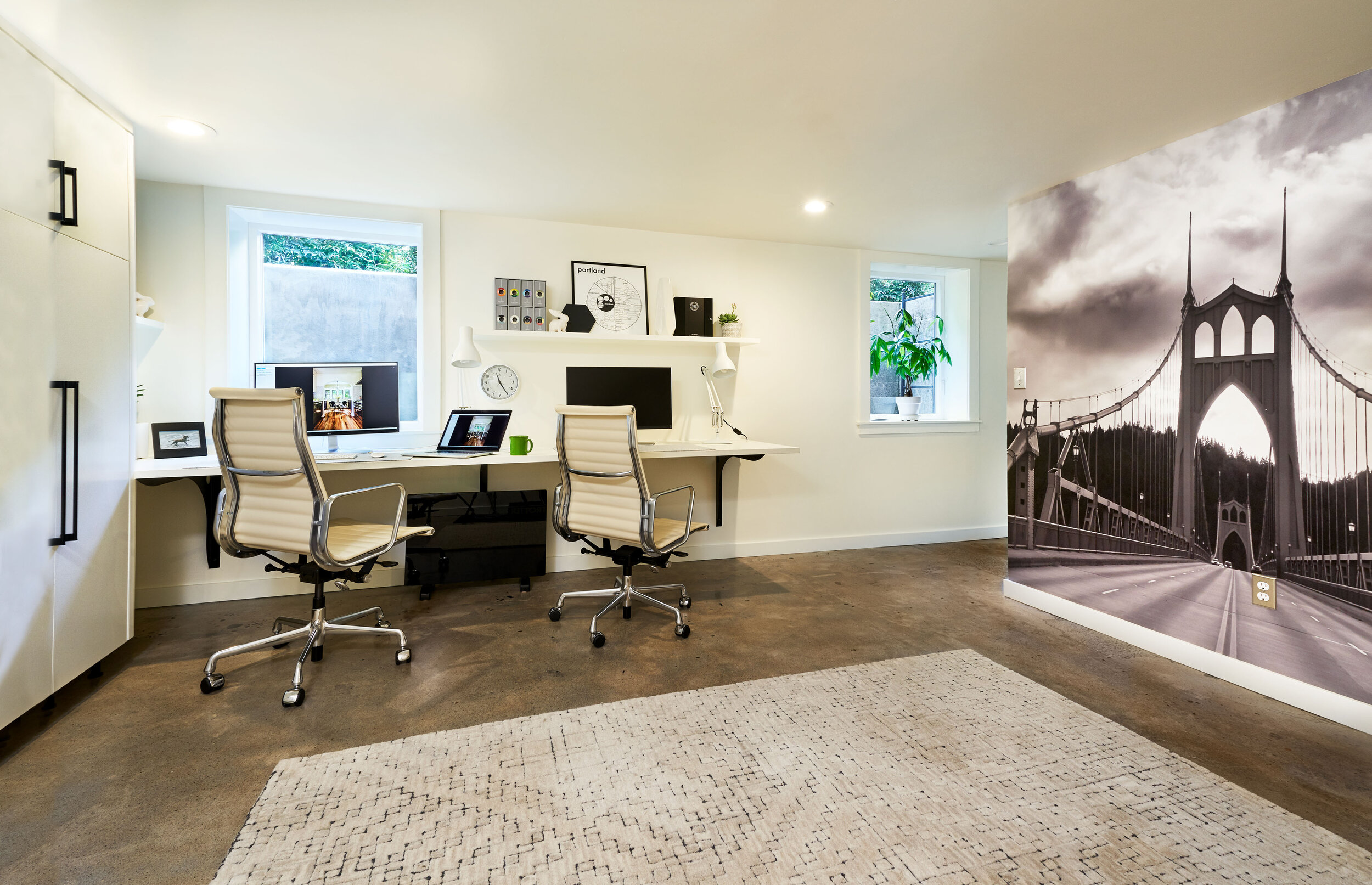 Industrial braces were used to create the open desk area. Custom wallpaper adorns the office wall.  