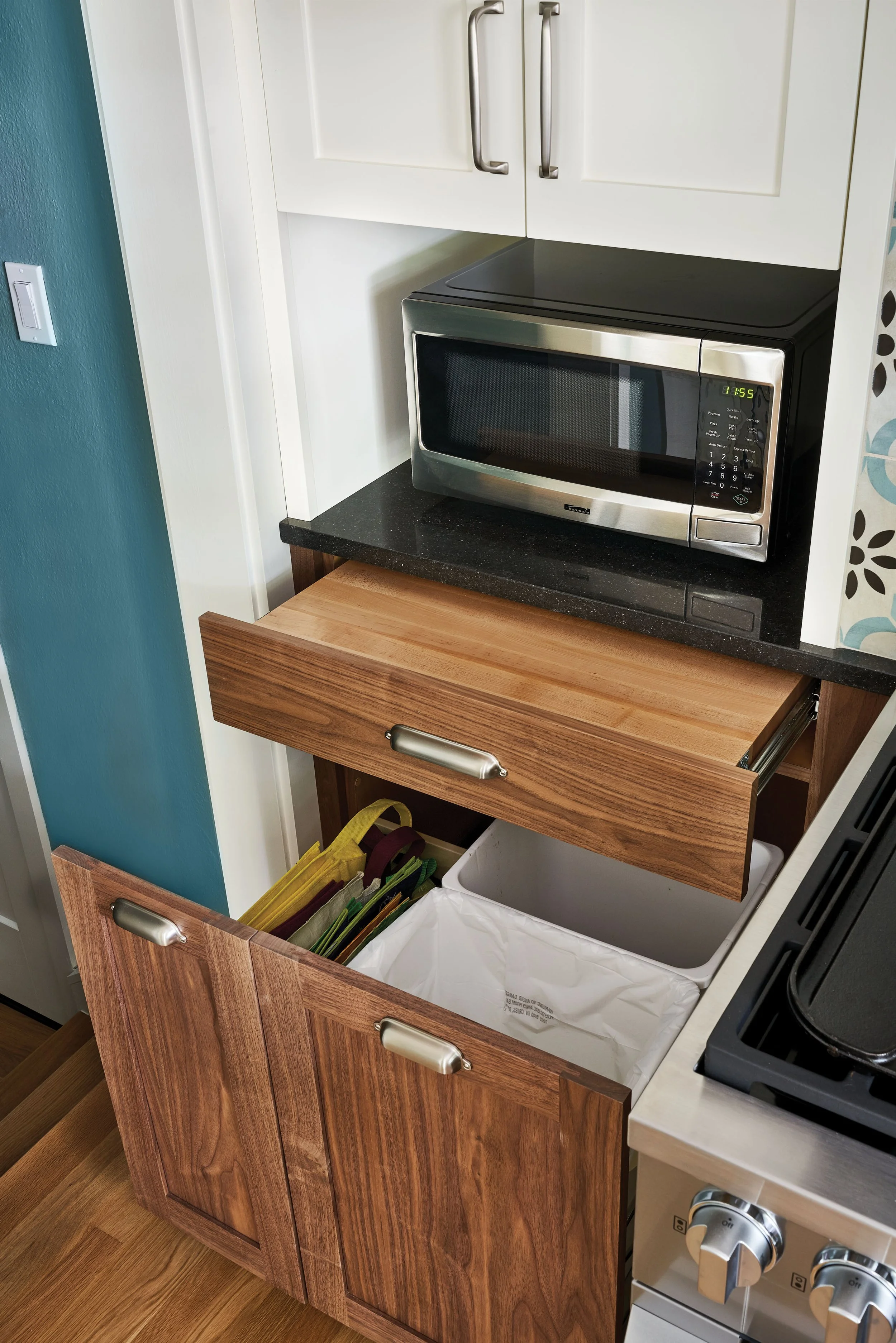 Pull-out counter space provides a landing area next to the range, or can be used for additional food prep. Trash/recycle pullout is located conveniently underneath.