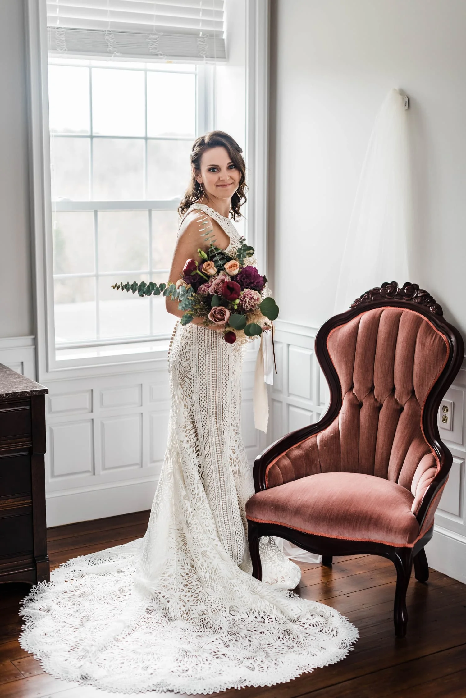 Bride interior shot beside chair at historic inn.jpg