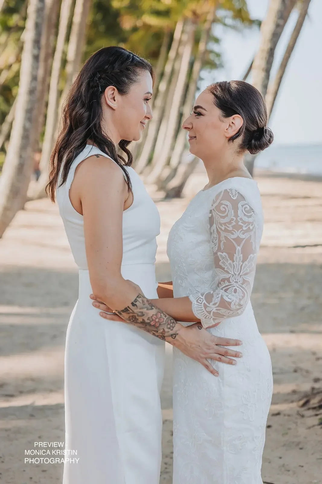 Same sex couple eloping amongst palm trees facing the ocean in Cairns with I Do Drive Thru — elopement celebrant from $400