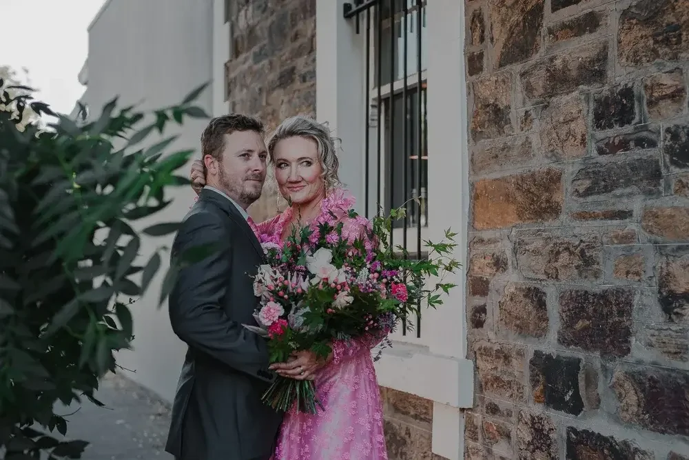 Couple photographed outside their home after eloping with I Do Drive Thru — elopement celebrant and photographer from $400