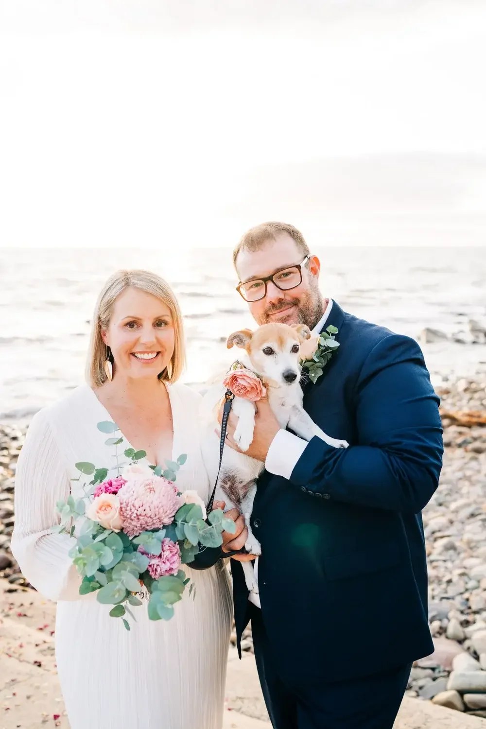 Couple just married on a Perth beach holding their dog with I Do Drive Thru — elopement celebrant from $400