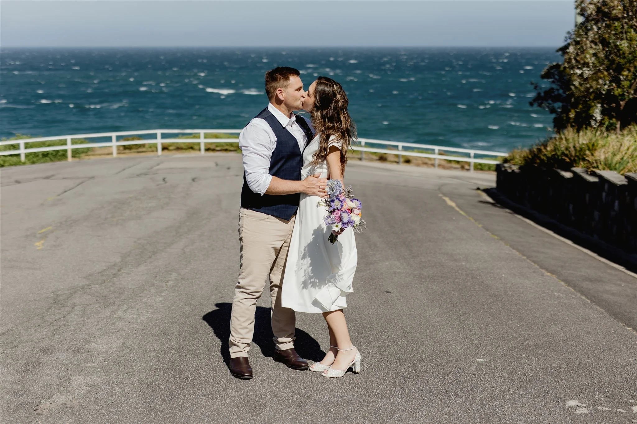 Newly eloped couple kissing at King Edward Park Newcastle during their portrait session with I Do Drive Thru — elopement celebrant from $400