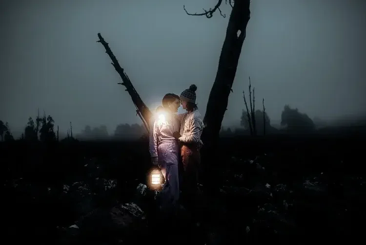 Same sex couple eloping at sunrise on kunanyi Mount Wellington Hobart with lanterns with I Do Drive Thru — elopement celebrant from $400