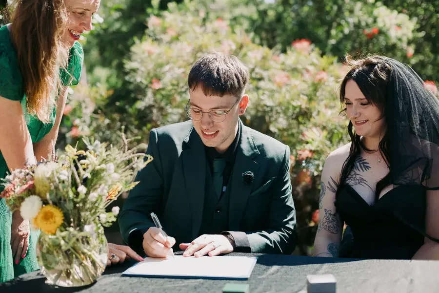 Couple signing their marriage paperwork in Warburton in the Yarra Valley with I Do Drive Thru — elopement celebrant from $400