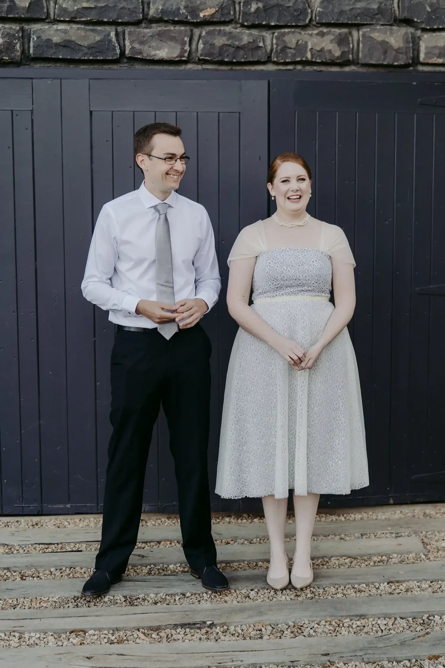 Couple standing in front of their shed in the eastern suburbs of Melbourne after eloping with I Do Drive Thru — from $400