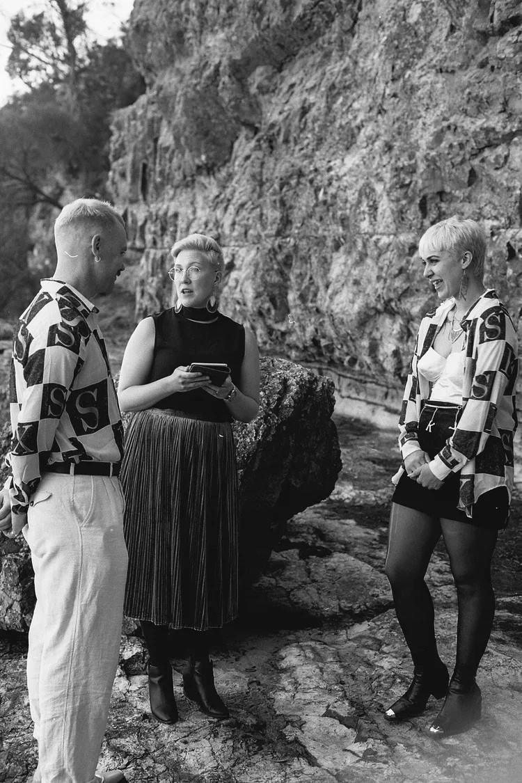 Couple eloping on the beach in Tasmania wearing matching shirts with I Do Drive Thru — secret elopement from $400