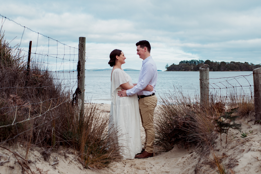 Budget wedding couple smiling outdoors with celebrant and photographer