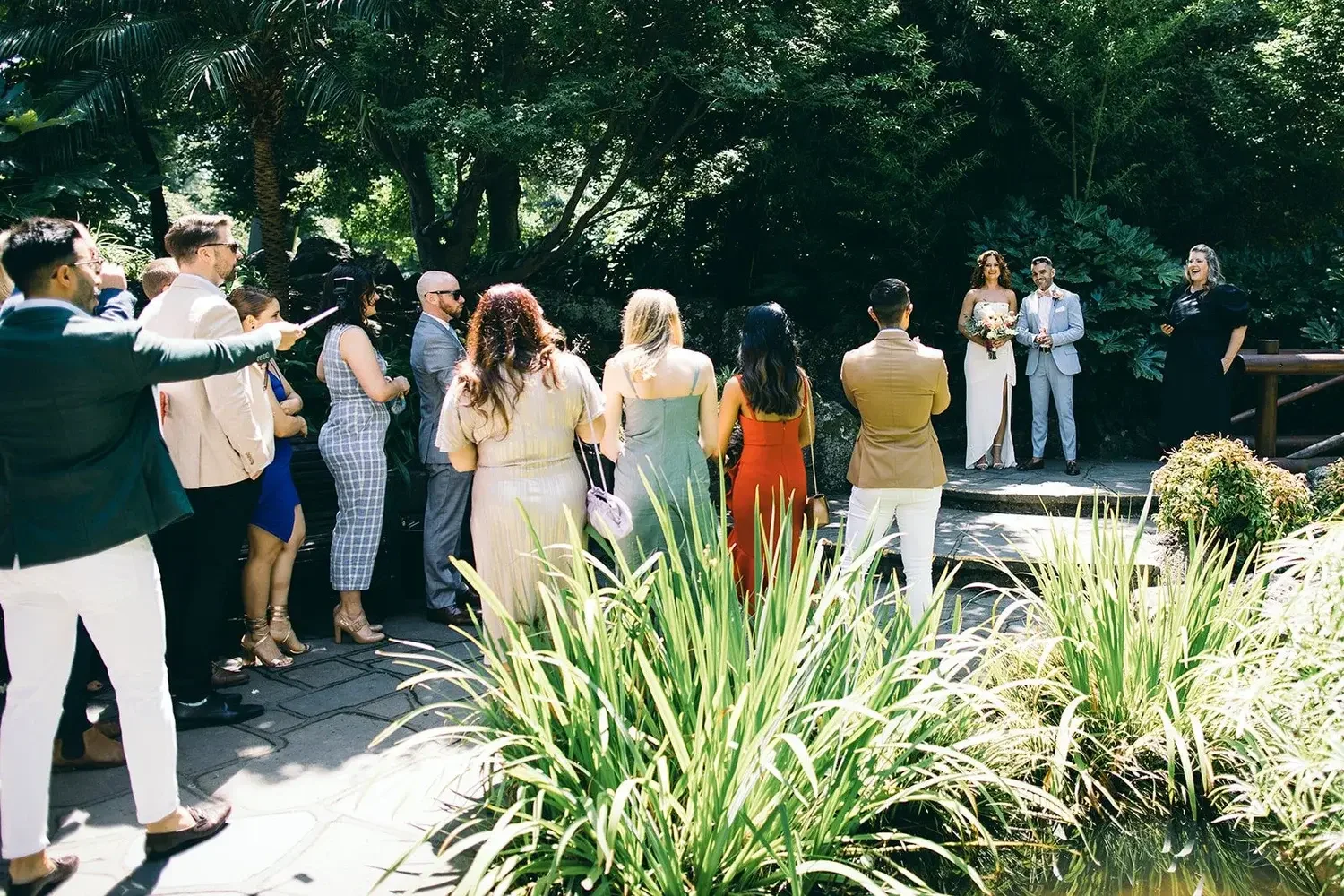 Guests casually gathering around a couple during their micro wedding ceremony at Fitzroy Gardens Melbourne with I Do Drive Thru — Fancy Pants Package from $600