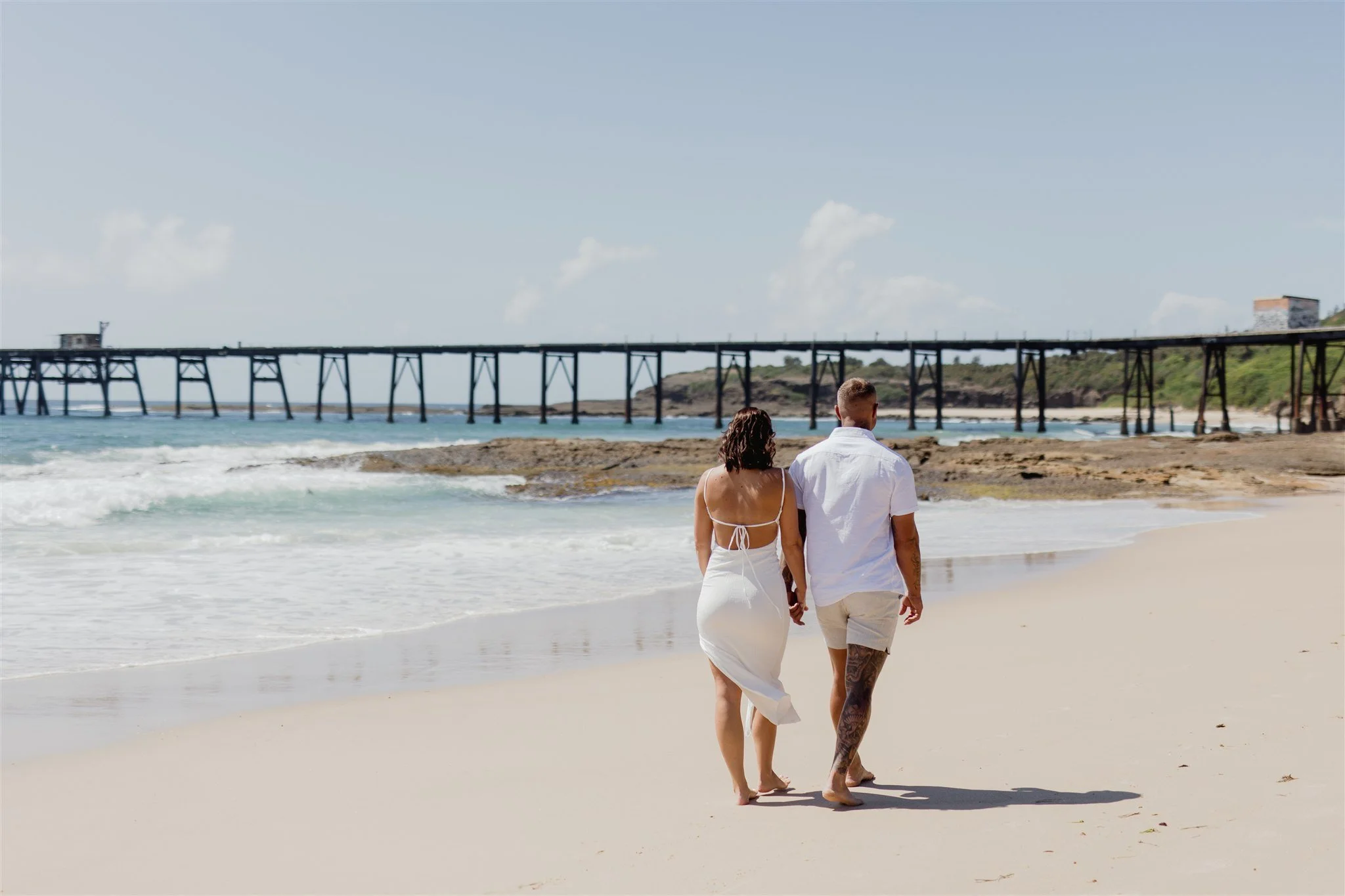 Couple walking barefoot along Catherine Hill Bay Beach after eloping with I Do Drive Thru — elopement celebrant Newcastle from $400