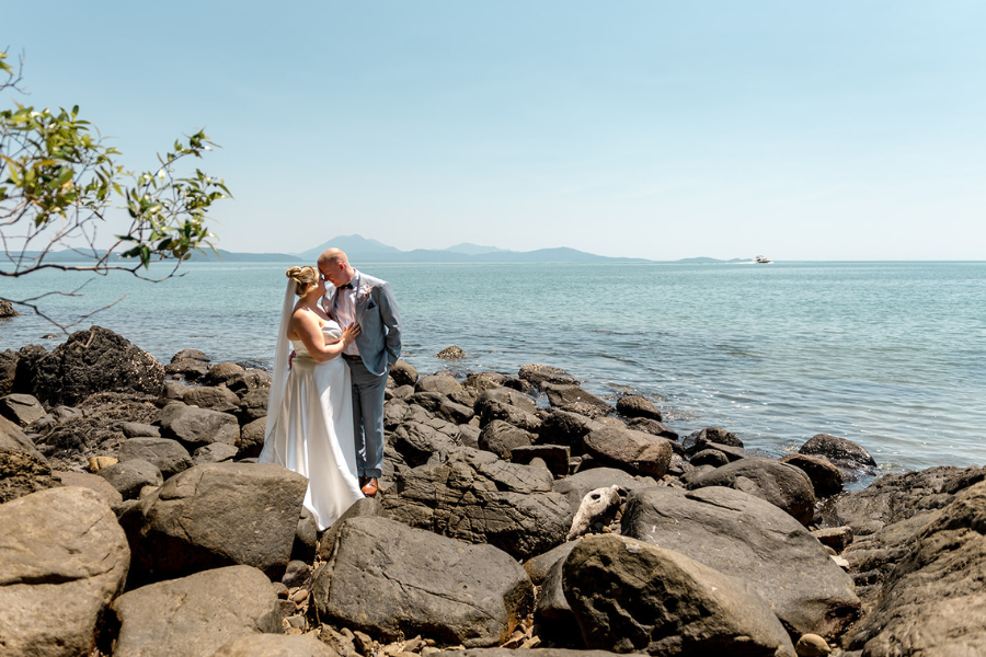Budget wedding couple smiling outdoors with celebrant and photographer