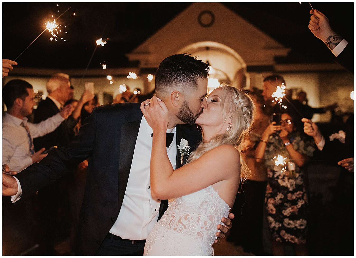 bride and groom kiss with sparklers