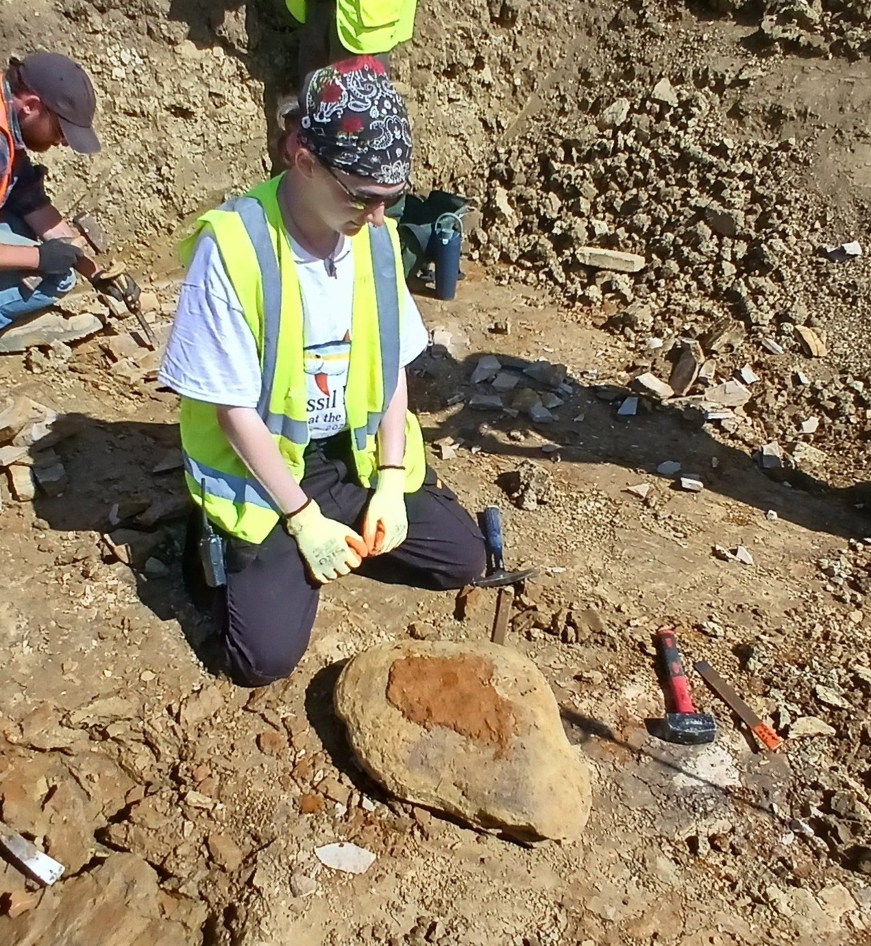 A man knelt on the ground next to a nodule