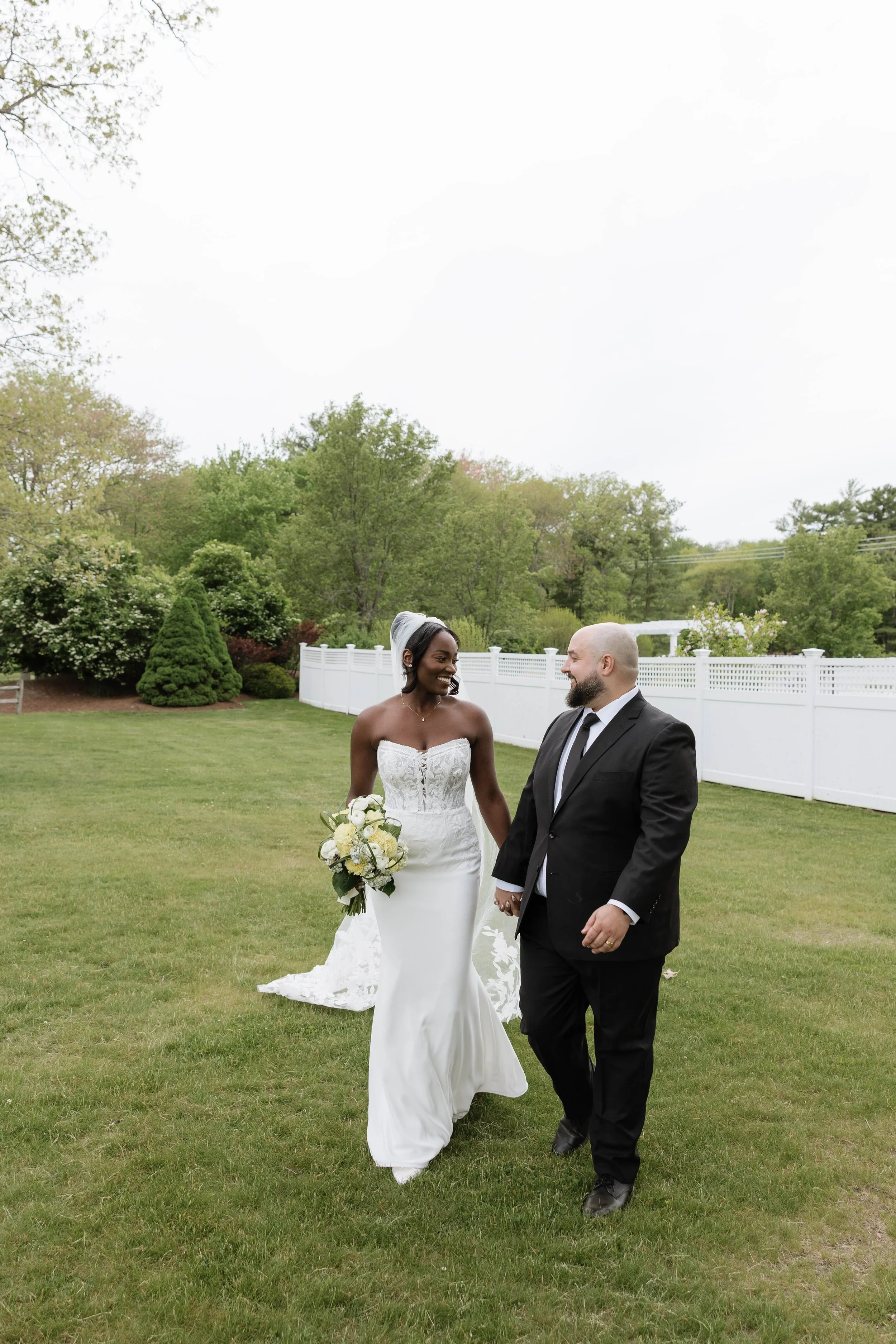 Bride and groom walking on a green lawn on a summer day