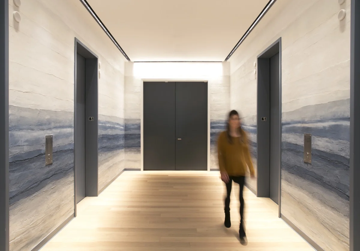 The plaster is designed to look like a foggy horizon above the Pacific Ocean in this elevator lobby.