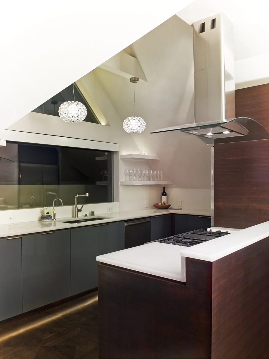 Warm wood grounds the kitchen, while off-white above the counters keep it feeling light.