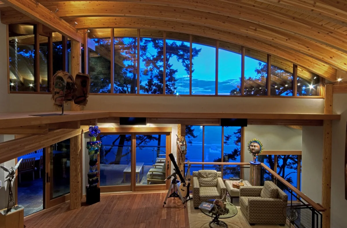 Large, curved wood beams accentuate the view out large windows.
