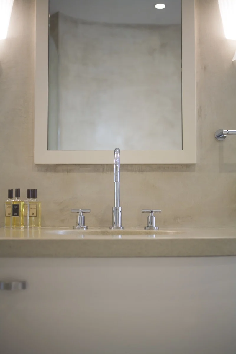 A smooth texture is calm near the sink in the bathroom.