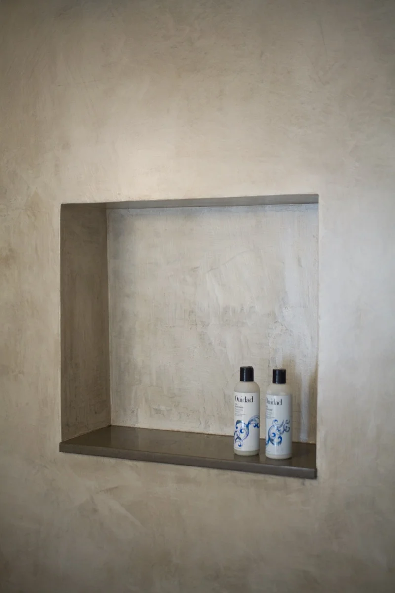 The artistic plaster finish continues to the shower cubby.