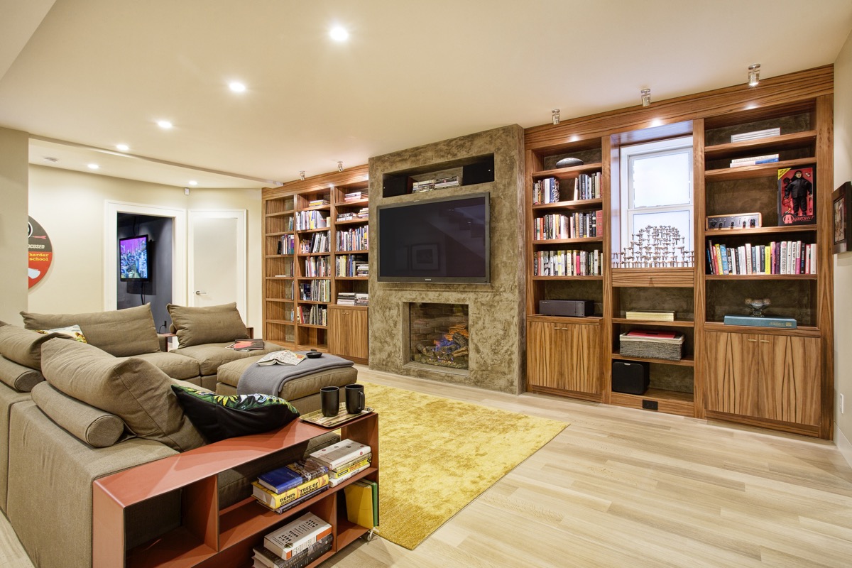 The masculine basement living room is anchored by a plaster column.