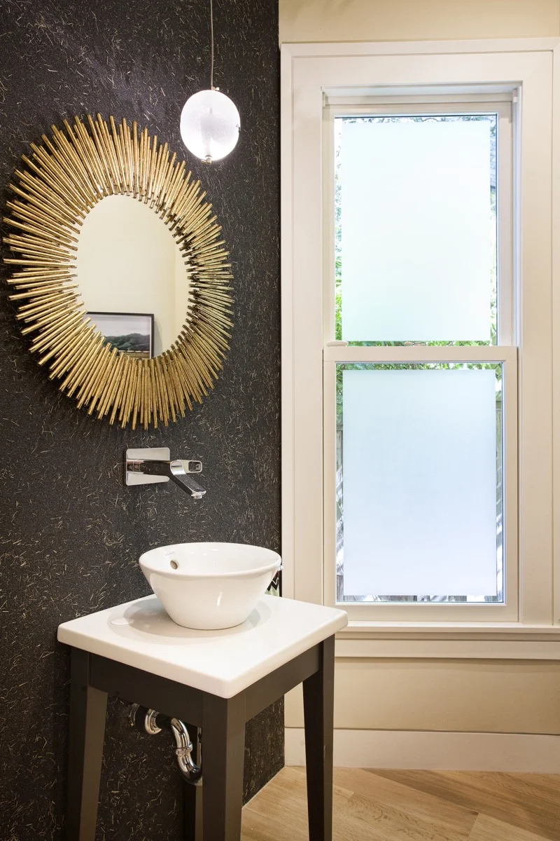 The powder room has a dark, composite finish.