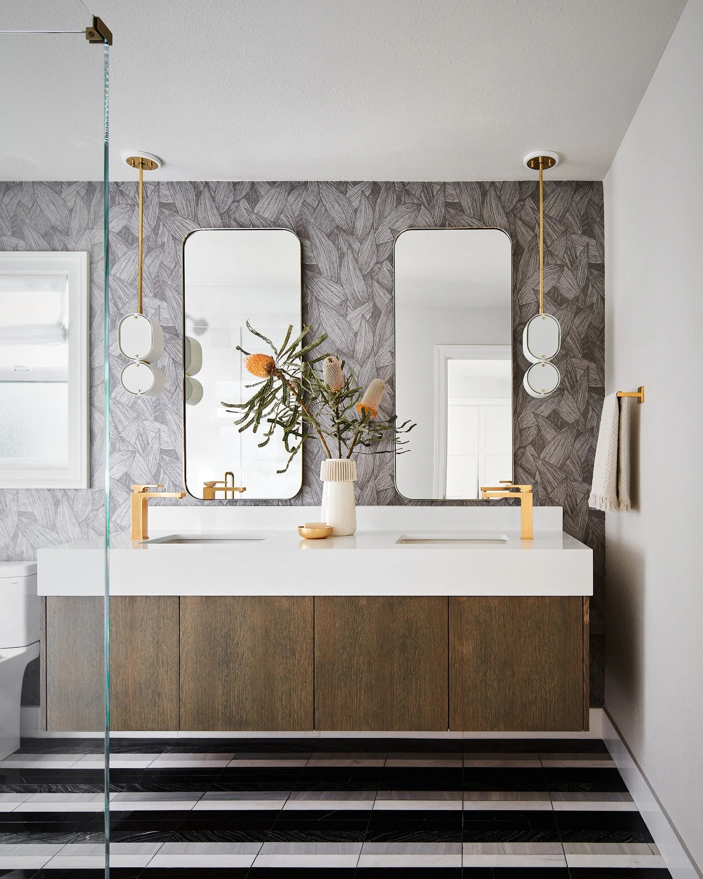 A guest bathroom at our #weatherlyproject is layered with a bold striped tile, monochromatic palm-print wallcovering, warm wood, and a pop of brass for a visually interesting space that shines. #caseyhowardinteriordesign
📸: @kuohphotography
styling: