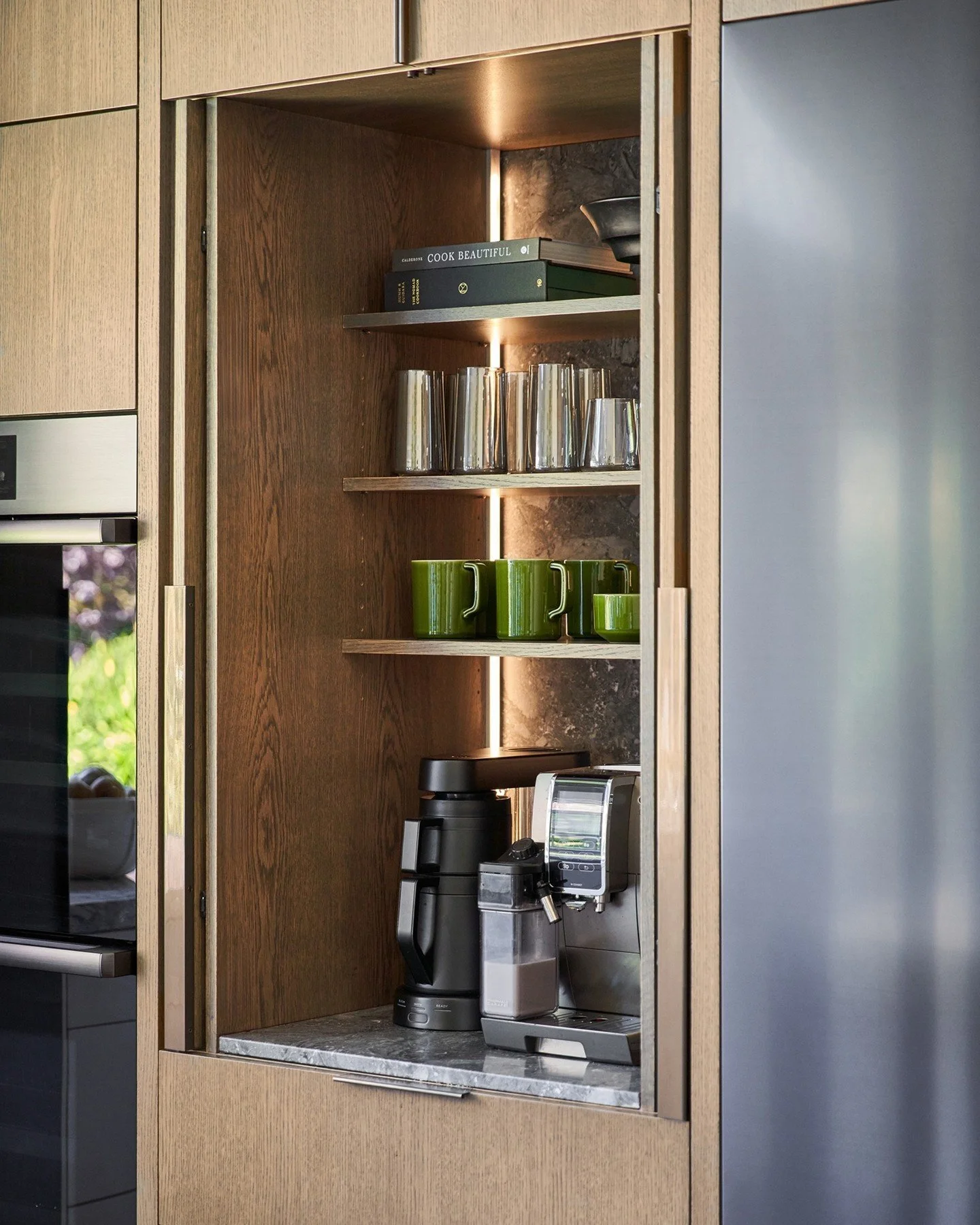 A coffee and beverage bar is one of those thoughtful details that elevates everyday living. Designed to be both beautiful and functional, this custom space can be tucked away behind nesting cabinet doors or opened completely for entertaining. The ful