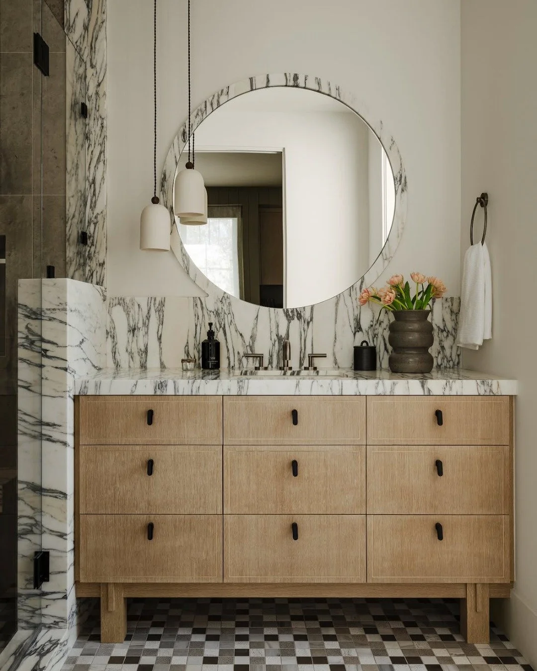 Take materials beyond their expected boundaries. Here, the stone extends from the shower to the vanity and framing the mirror, creating an unexpected continuity that adds depth, interest, and a beautifully considered layer of detail.
#inspo
design @m