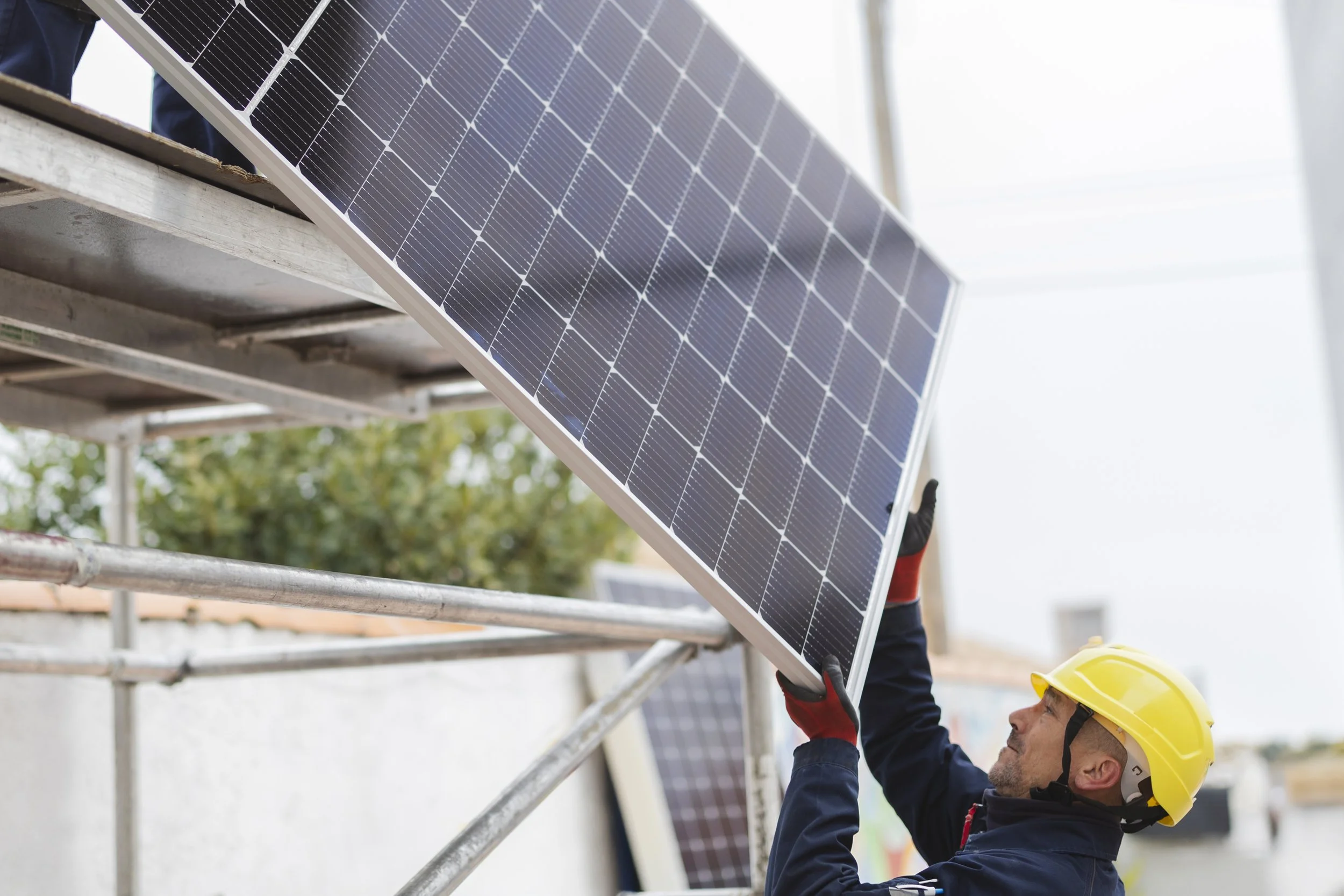 Workers installing or maintaining solar panels on a metal framework against a blue sky.