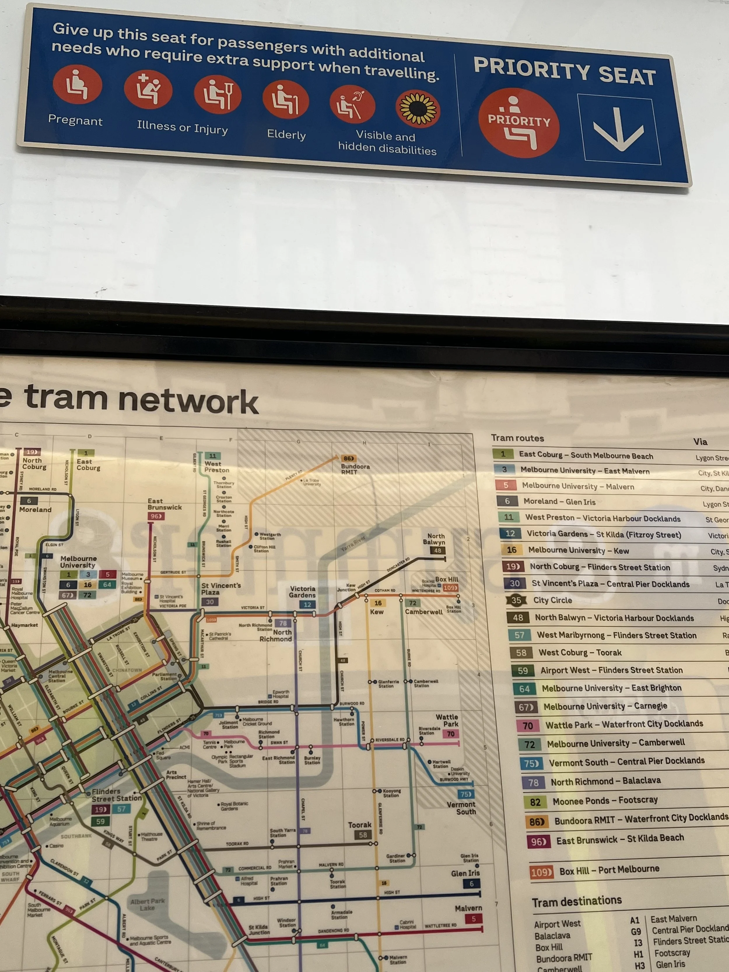  A close up of the Priority seat sign at the Swantson Street tram stop outside Flinders Street Sation with symbols indicating the different types of people who may need the seat. The hidden disability sunflower can be seen next to the disability symb