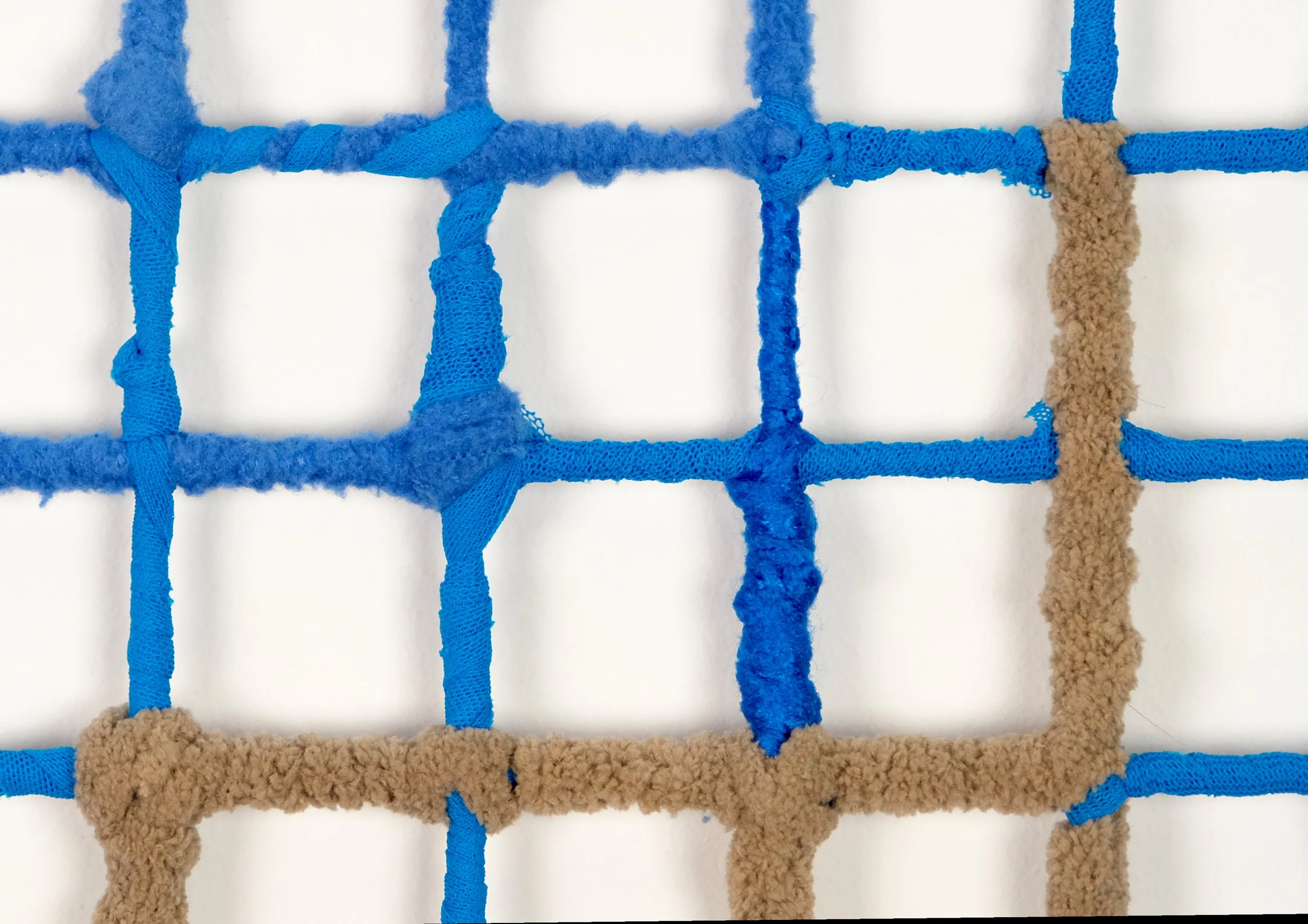  Cozy Cage Cube no. 2 (detail), 2025, Poly fleece, fabric, and yarn on wire storage cube, 14 x 14 inches 