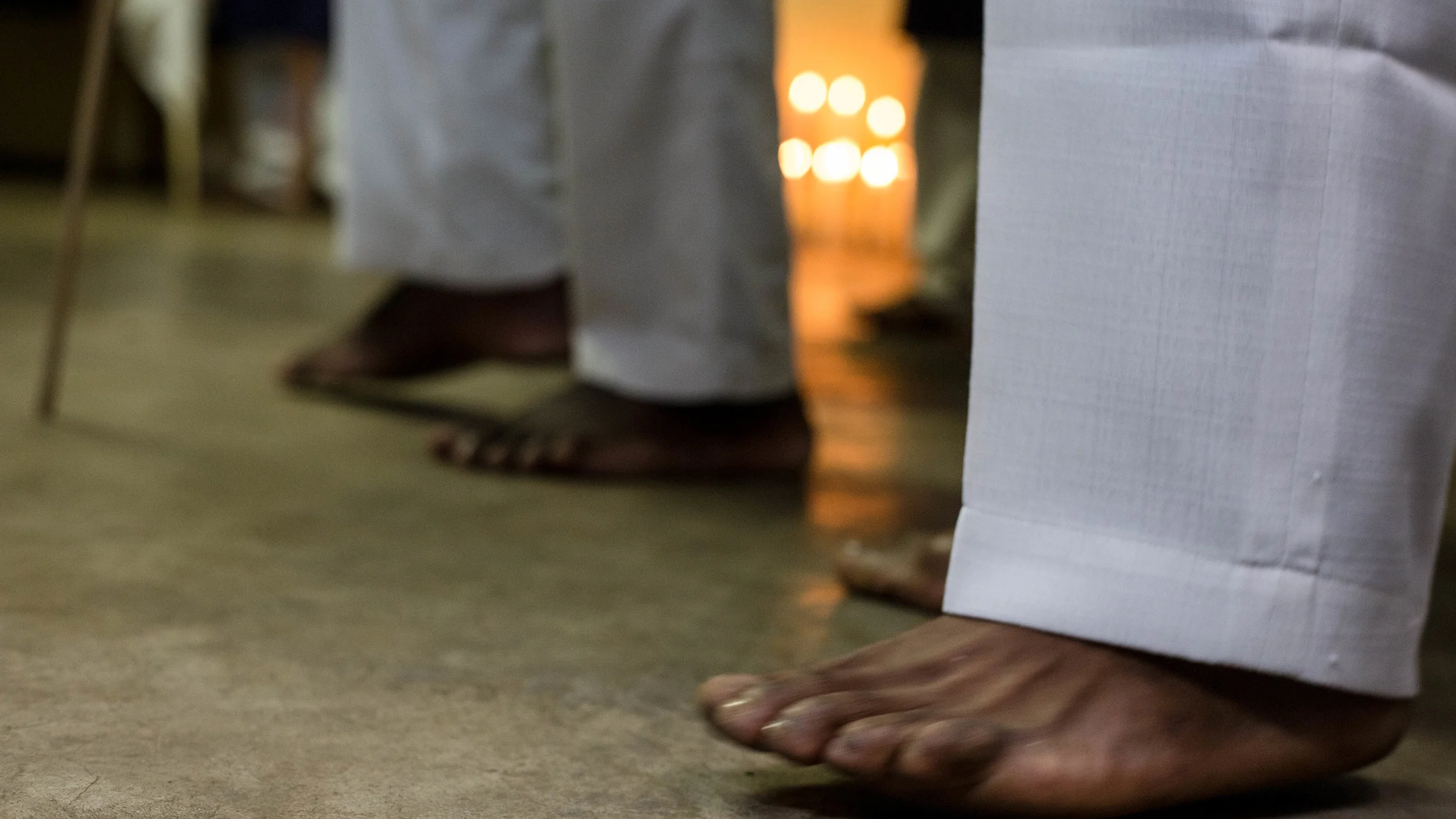 Feet of the members of the congregation stomping to the beat of the song. Candles, which were treated with intense reverence were kept lit in the corner of the room throughout the service, on Sunday, June 10, in Johannesburg, ZA. Photo: Wes Parnell.