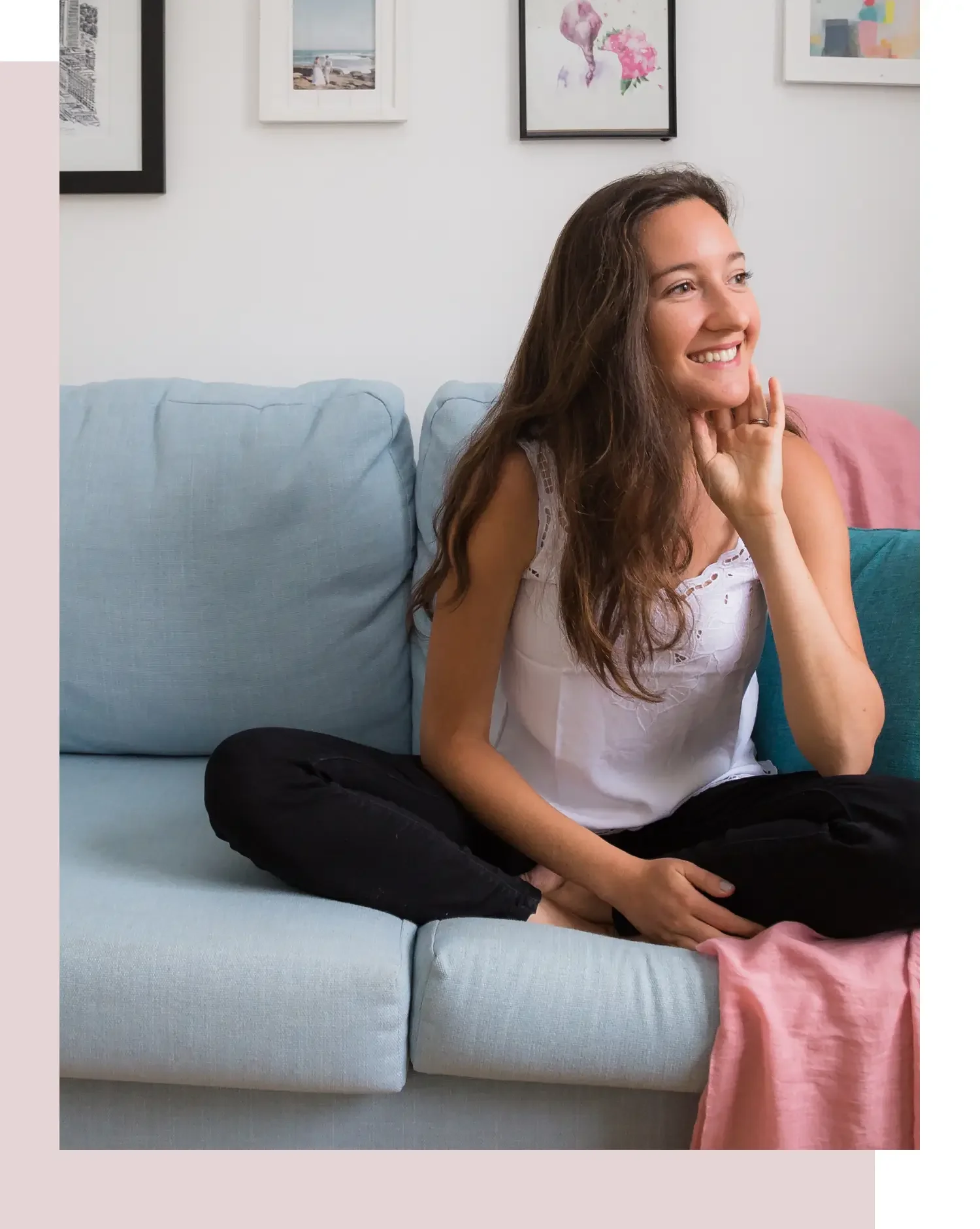 grace on couch with legs crossed smiling and looking off to the side