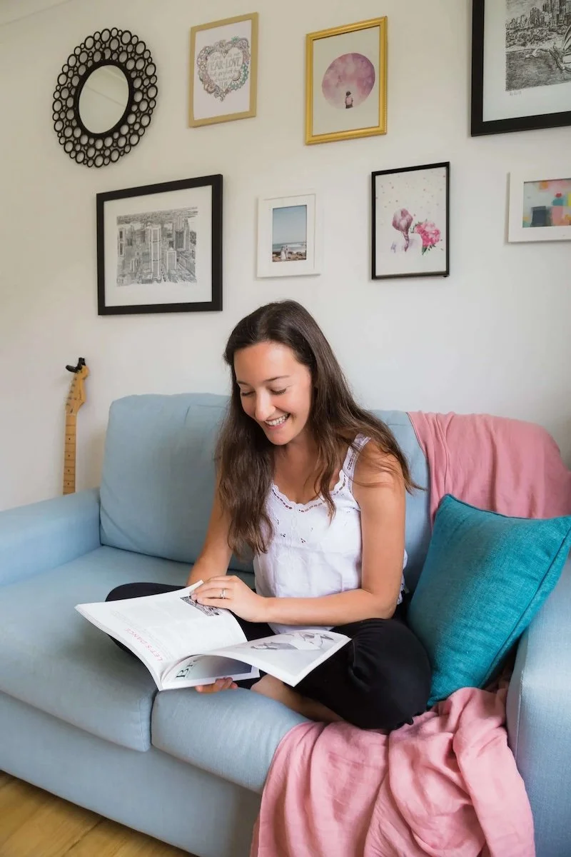 grace crossed legs on couch reading a book