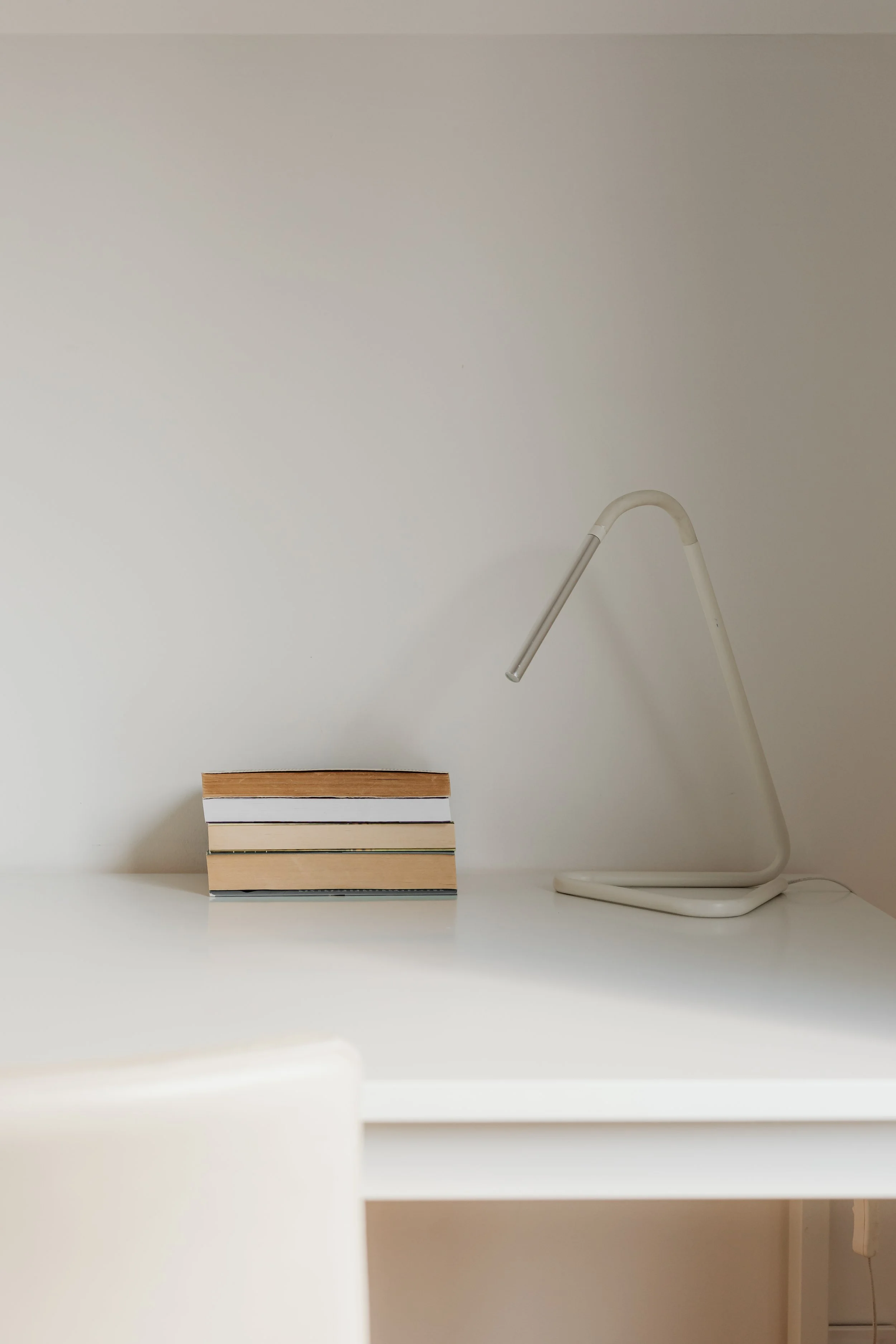 Minimalist desk with books and lamp