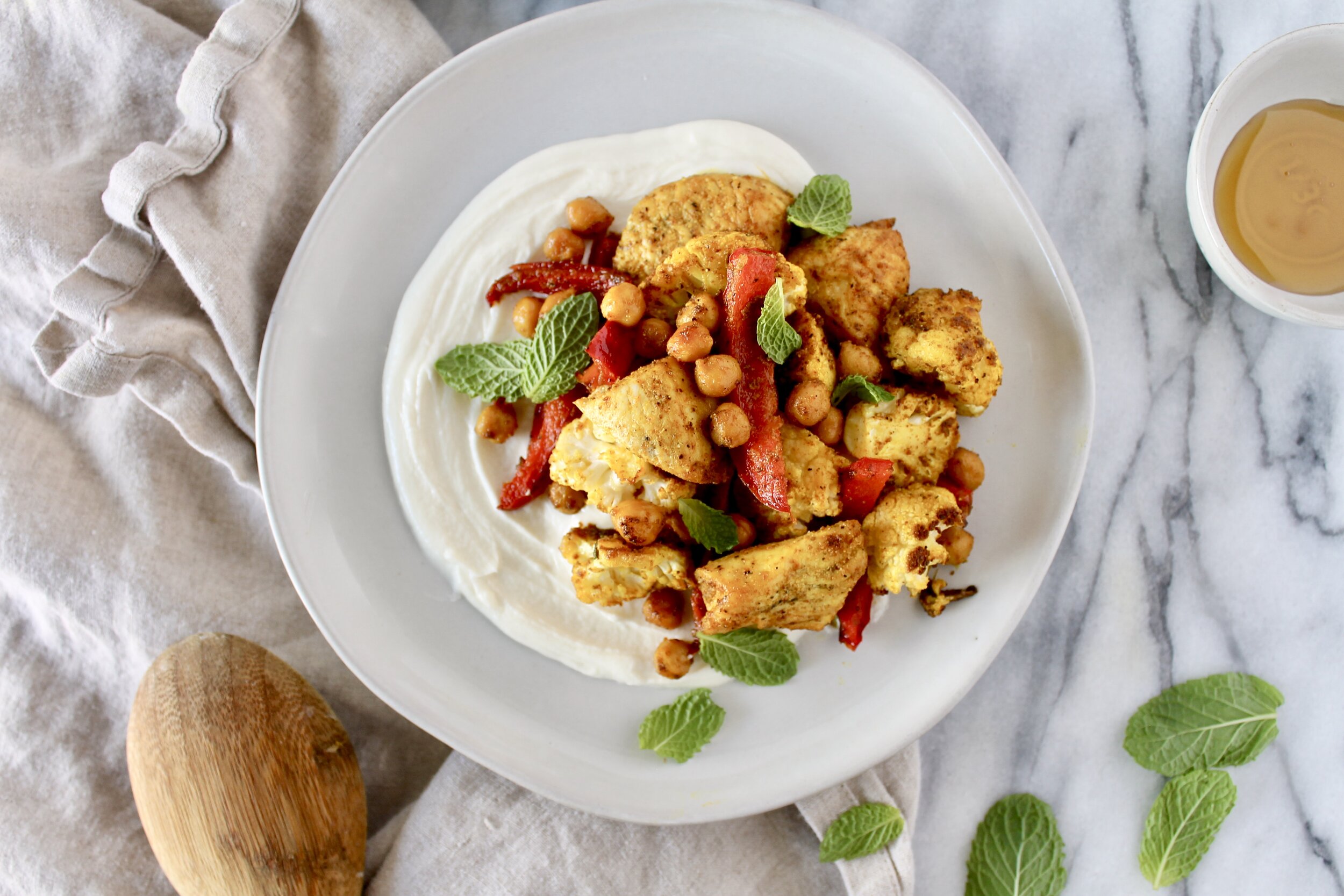 sheet pan turmeric spiced chicken, cauliflower, peppers, and chickpeas with whipped lemon honey