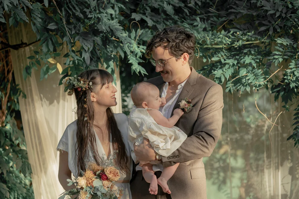  A bride and groom, a boho chic style NYC wedding look at each other lovingly under dappled light New York wedding photography. 