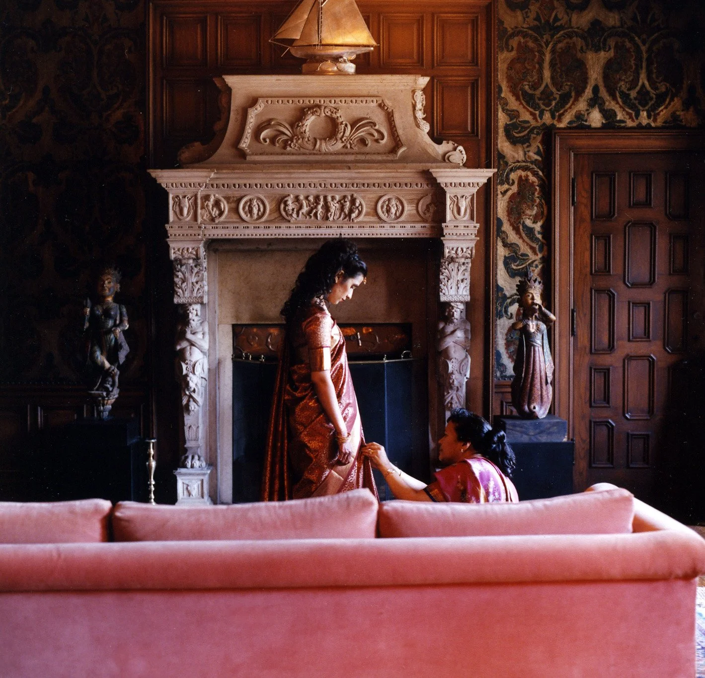  Indian Bride and mom prep for her wedding in front of an ornate mantle 