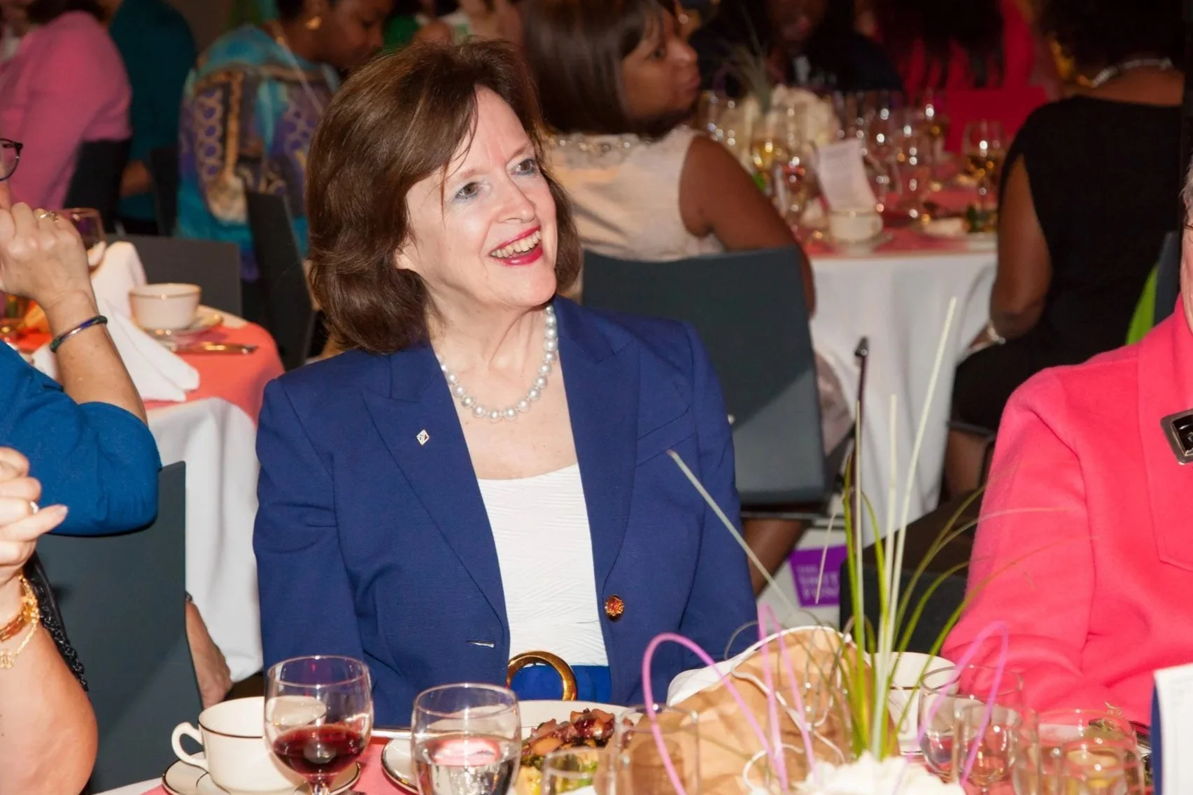  Woman at a New York fundraising gala listens to a speech at a banquet table and NYC Corporate photographer Elizabeth Solaka is working the event. 
