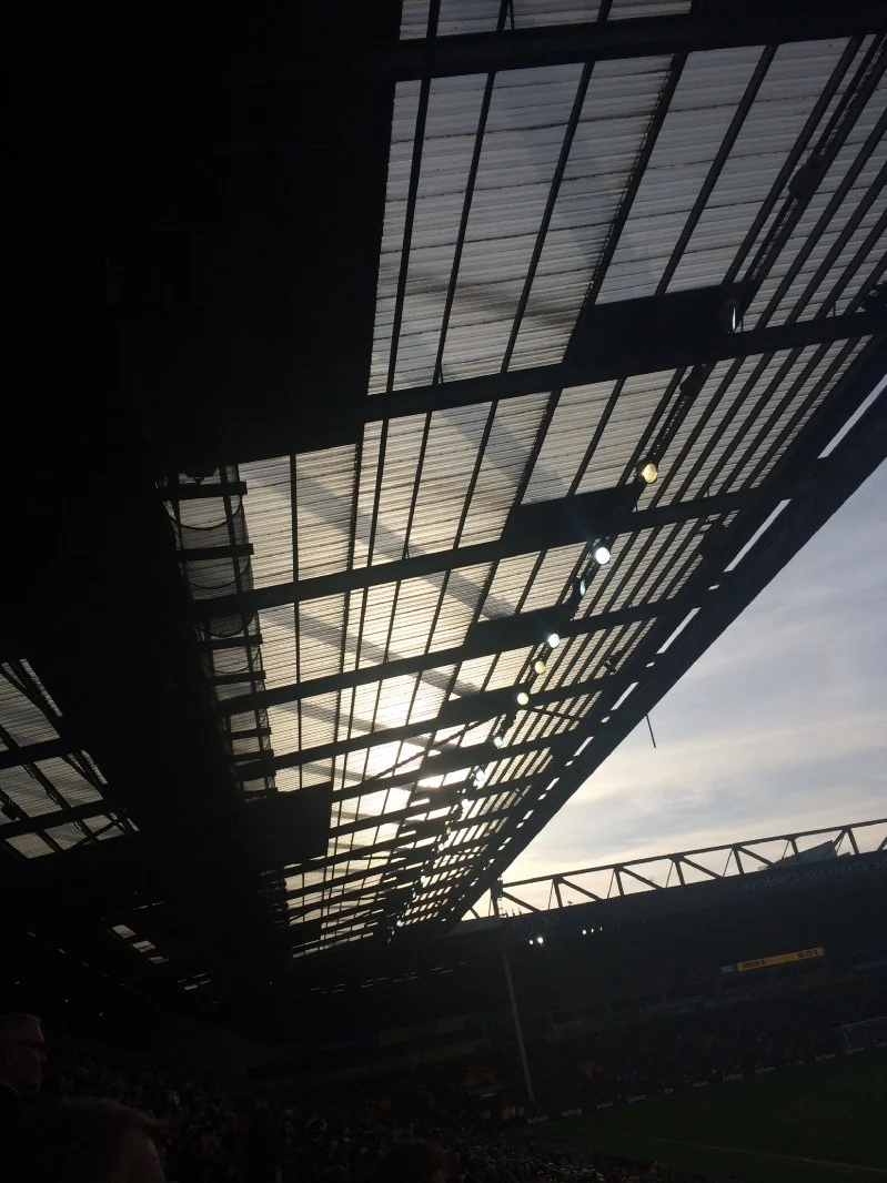 Second-half sun through the South Stand roof.