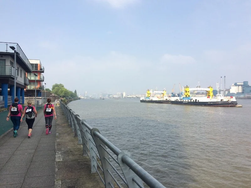 Westward past the unused ferries. Barrier ahead, Tate & Lyle over the river.