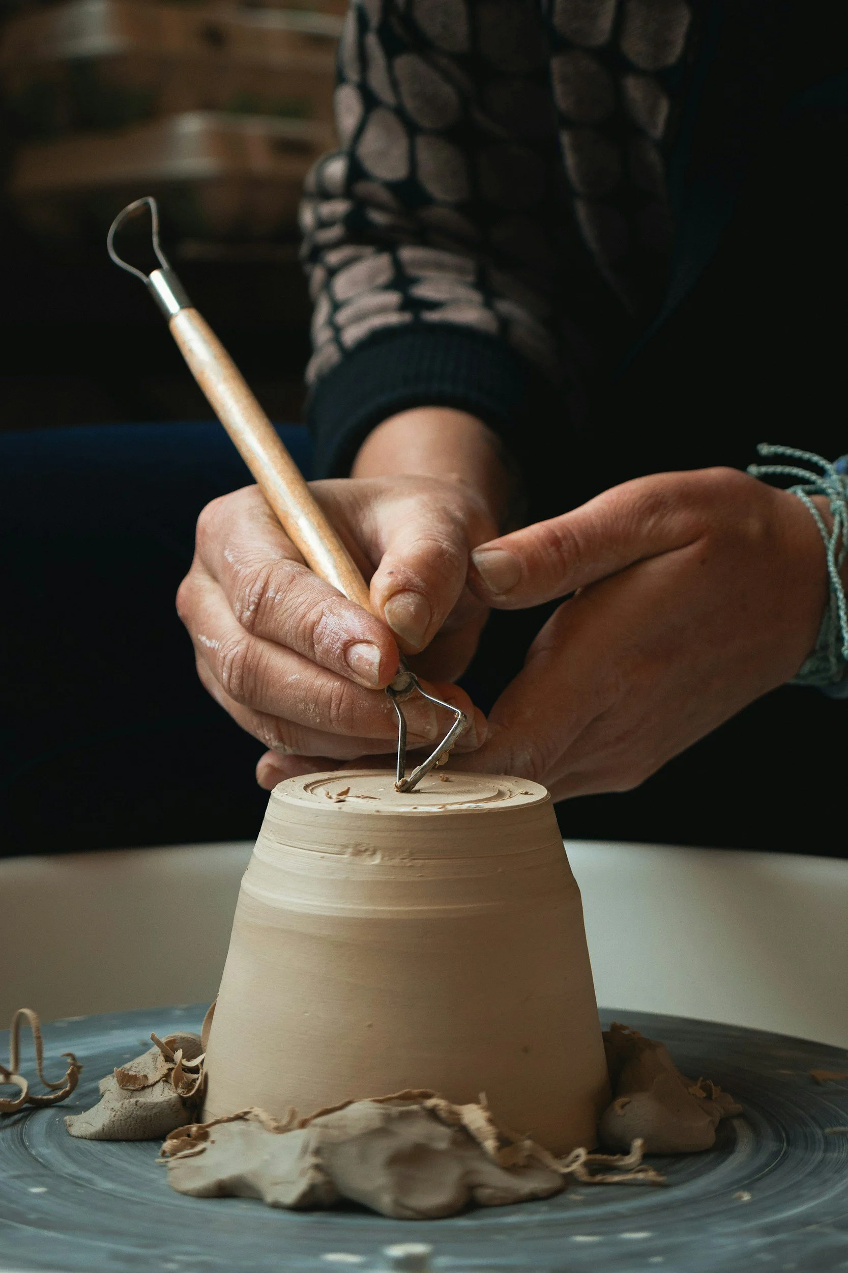 Close-up of artist's hands shaping pottery for Norman Firehouse.