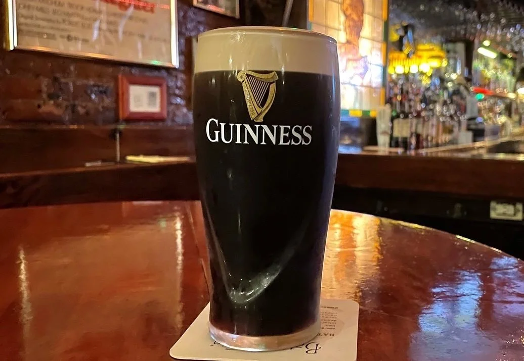A pint of Guinness on a table in a bar.