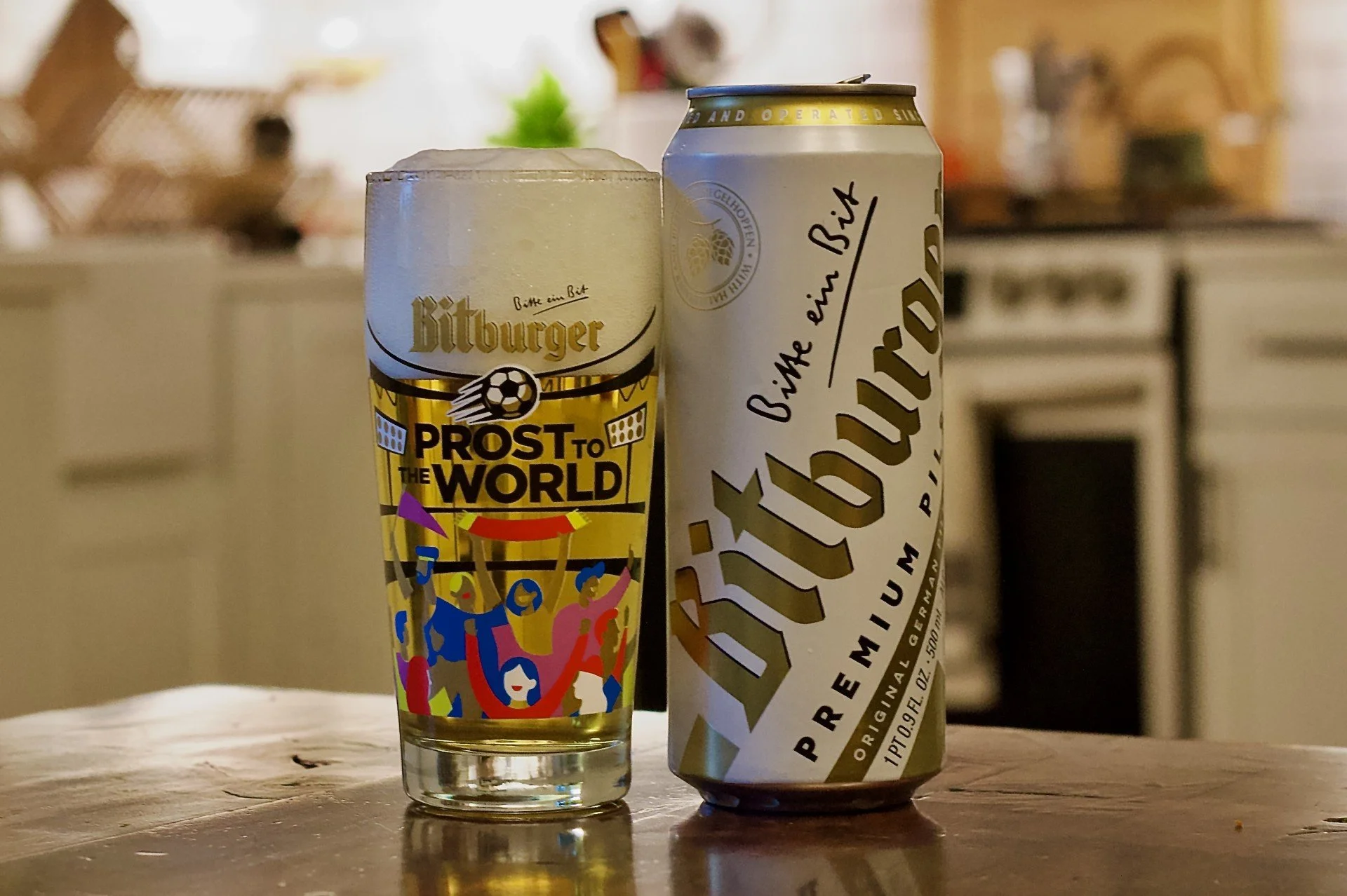 Bitburger can next to a Bitburger Wili Becher glass.