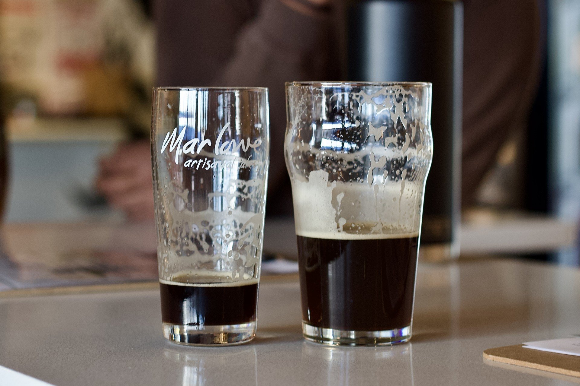 Two different glasses of the same stout.