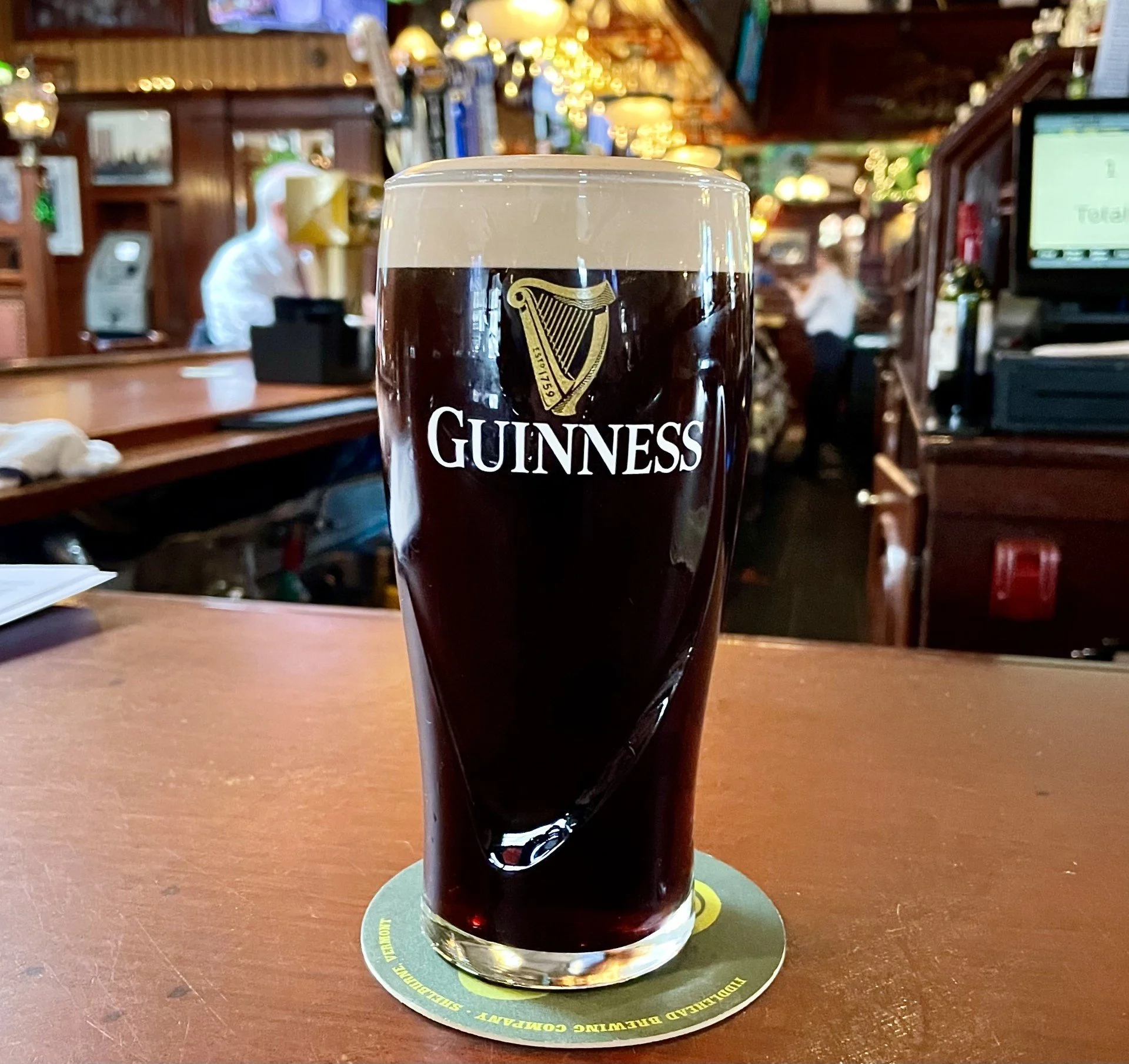 A pint of Guinness on a bar.