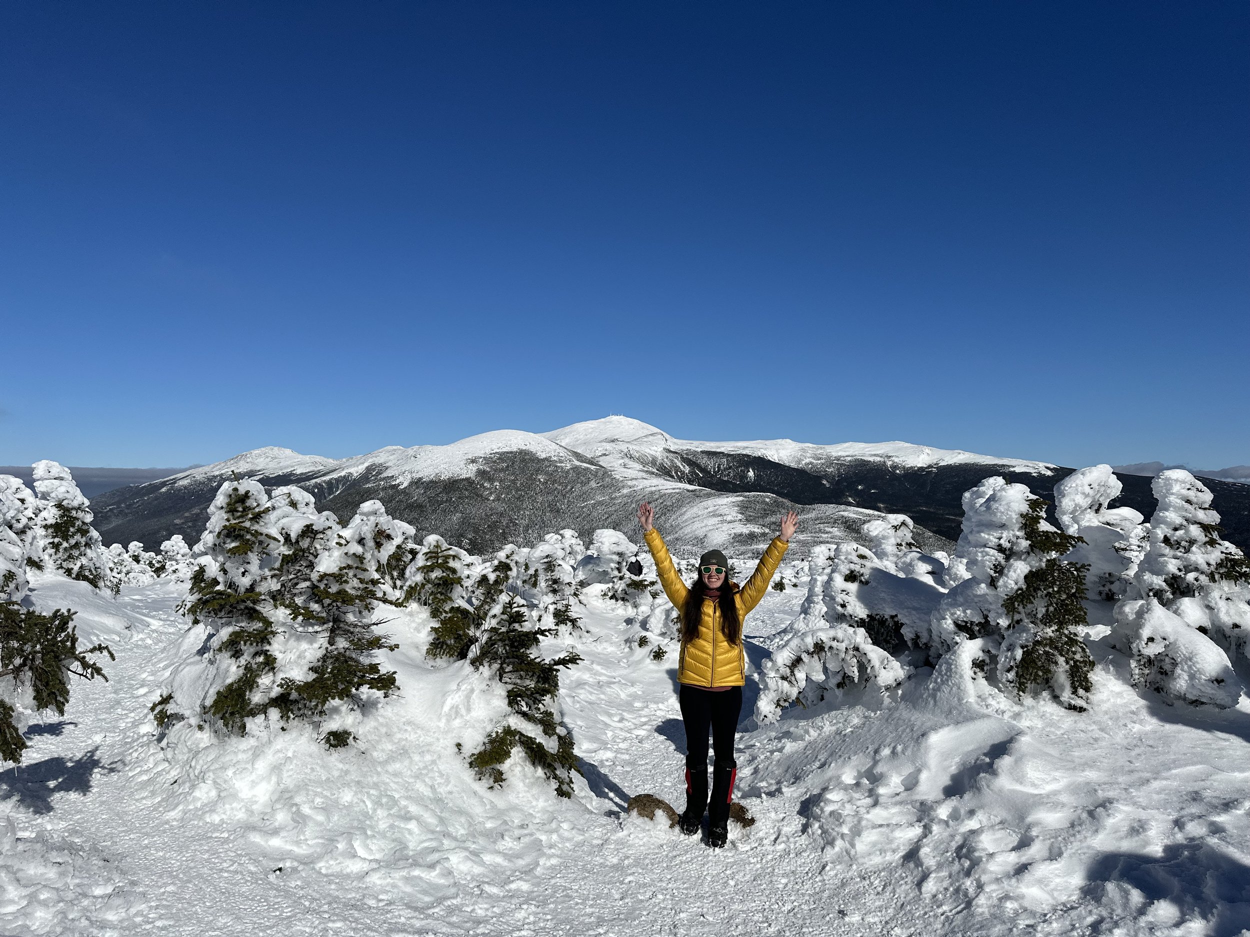 girl standing with arms up on mount pierce in the winter