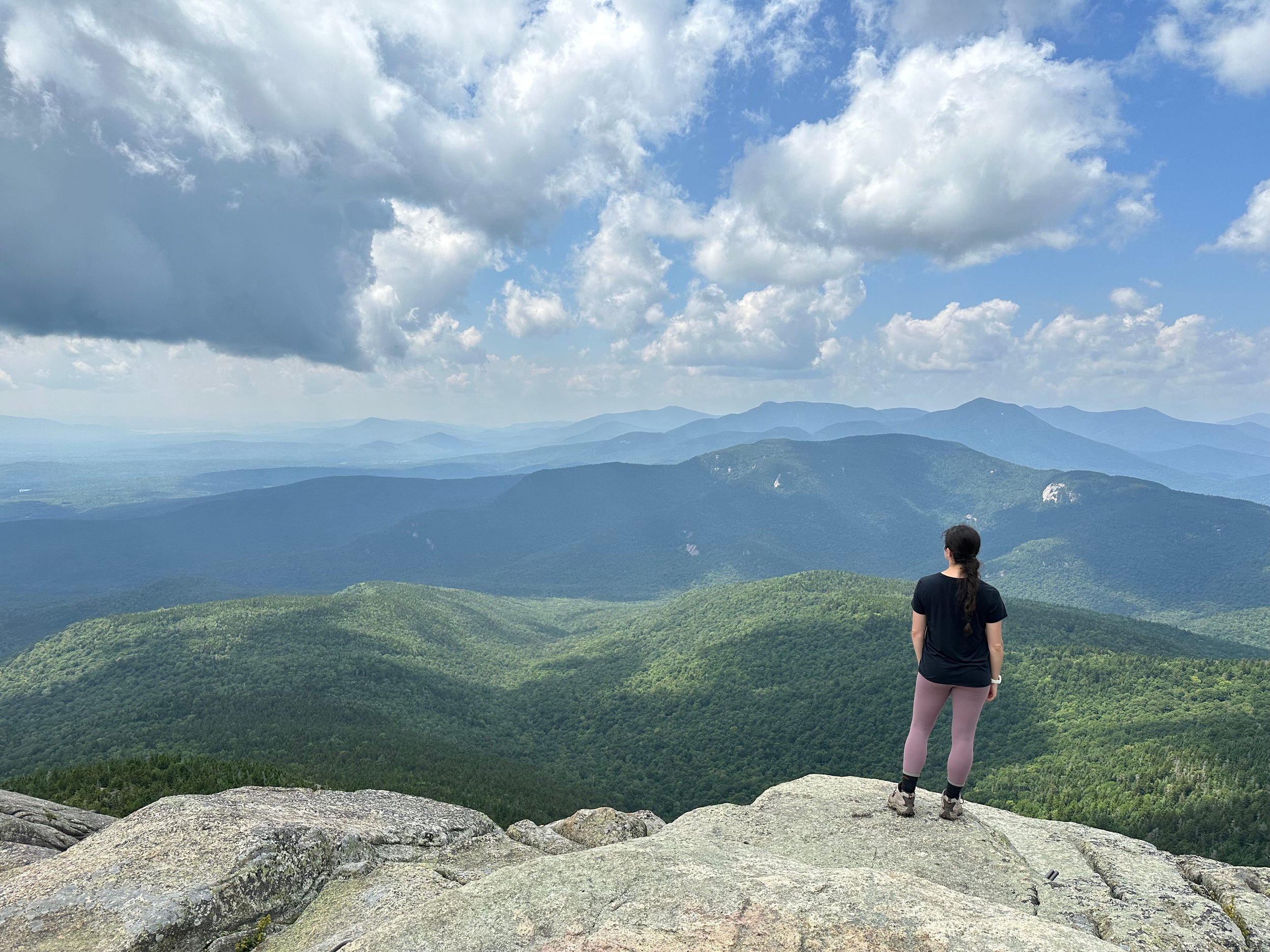 girl standing on mount chocorua looking out to views